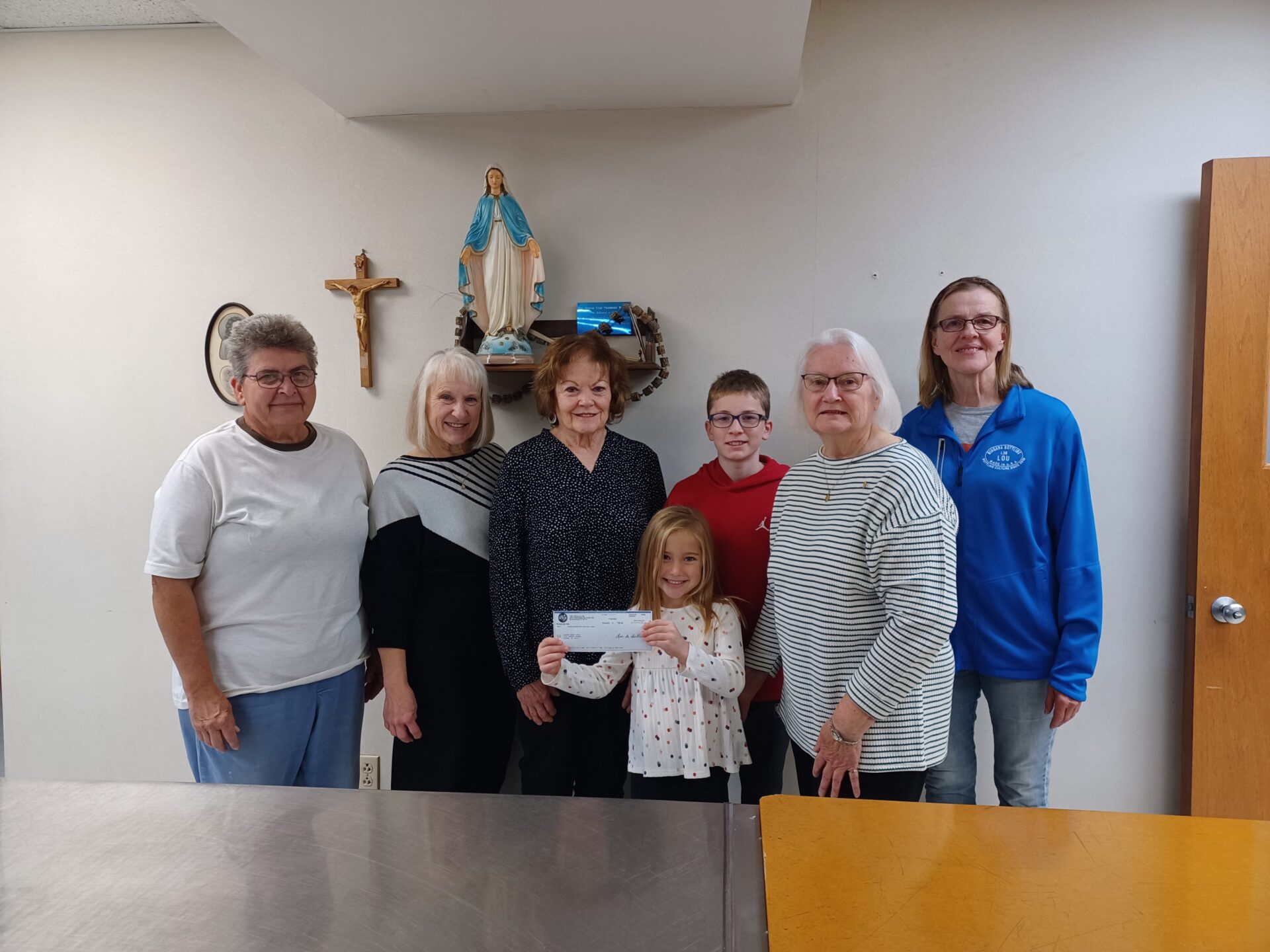 Impact Team 306 presents check from Pizza fundraiser for parish kitchen repairs